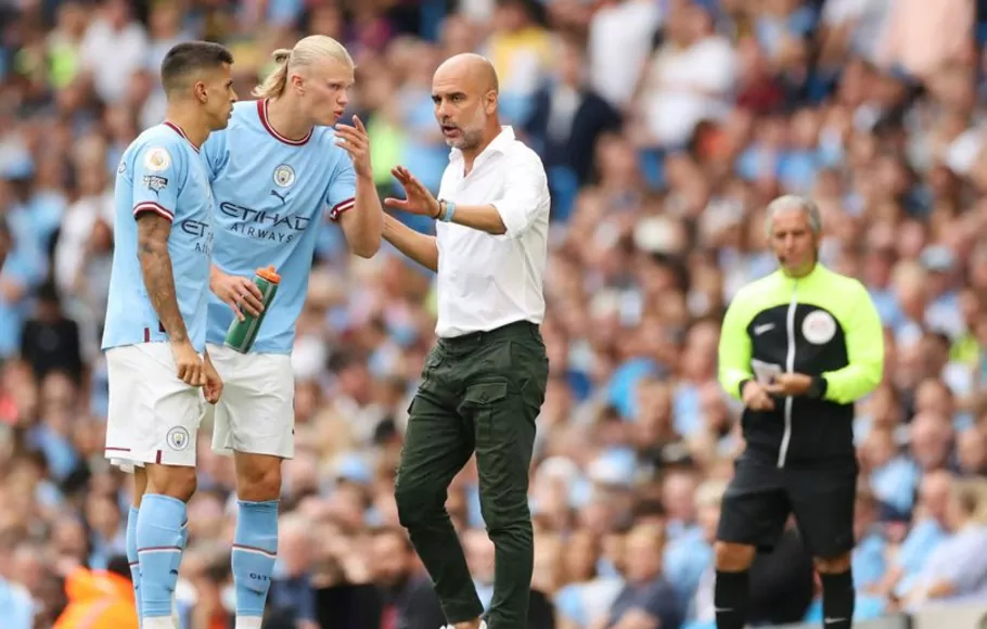 Pelatih Manchester City, Pep Guardiola, memberikan instruksi kepada dua pemainnya Erling Haaland (kedua kiri) dan Joao Cancelo. 