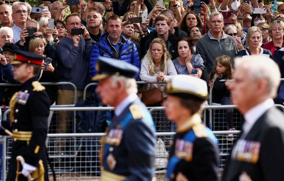 Warga Inggris berkumpul saat Raja Charles III, Putri Anne, dan Pangeran Andrew mengikuti peti mati Ratu Elizabeth II selama prosesi dari Istana Buckingham ke Istana Westminster, di London pada 14 September 2022.