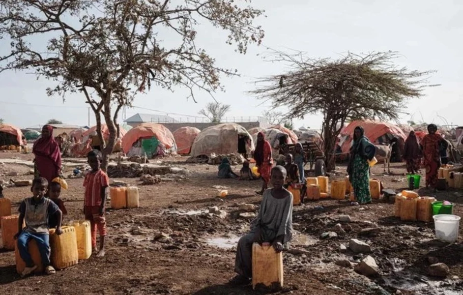 Orang-orang menunggu air dengan kontainer di satu kamp, ​​salah satu dari 500 kamp pengungsi internal (IDP) di kota, di Baidoa, Somalia pada 13 Februari 2022.