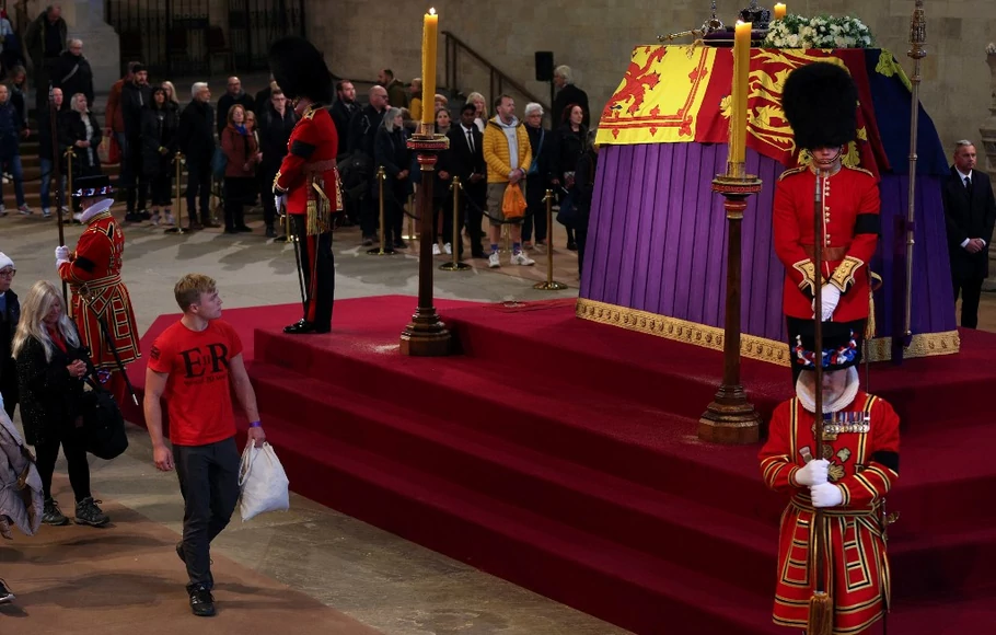 Anggota masyarakat memberi penghormatan saat mereka melewati peti mati Ratu Elizabeth II, di Westminster Hall, di Istana Westminster di London pada 18 September 2022.