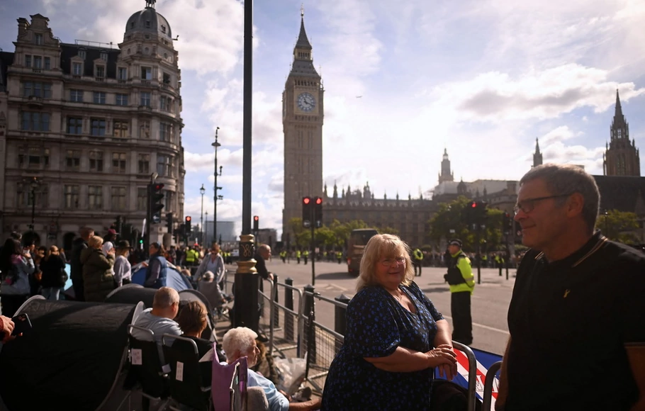 Para pekemah mengambil posisi di samping penghalang yang melapisi rute prosesi, menjelang pemakaman pada hari Senin mendiang Ratu Elizabeth II, di London pada Minggu 18 September 2022. Inggris sedang bersiap-siap pada Minggu untuk pemakaman kenegaraan penting Ratu Elizabeth II.