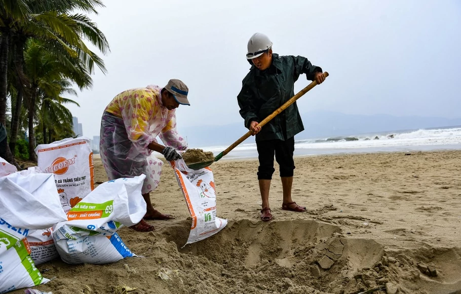 Warga menyiapkan kantong pasir untuk mengamankan rumah mereka sebelum topan super Noru menghantam Vietnam, di sebuah pantai di Danang pada 27 September 2022.