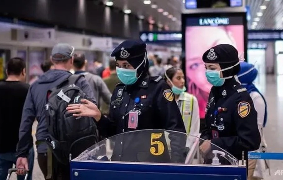 Petugas keamanan Malaysia melakukan pengawasan pada para penumpang pesawat. 