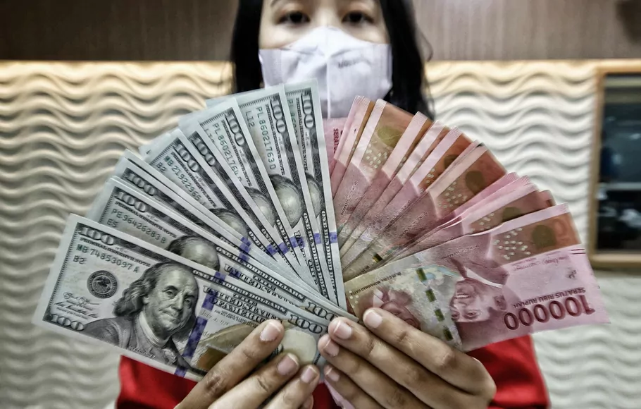 Petugas jasa penukaran mata uang asing menunjukan pecahan uang dolar Amerika Serikat dan pecahan uang Rupiah di tempat jasa penukaran uang di Kwitang, Jakarta Pusat, Kamis 29 September 2022.