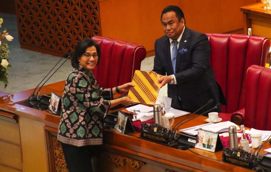 Menteri Keuangan Sri Mulyani menyerahkan dokumen kepada Wakil Ketua DPR Rachmat Gobel dalam rapat paripurna DPR di kompleks Parlemen, Senayan, Jakarta, Kamis, 29 September 2022.