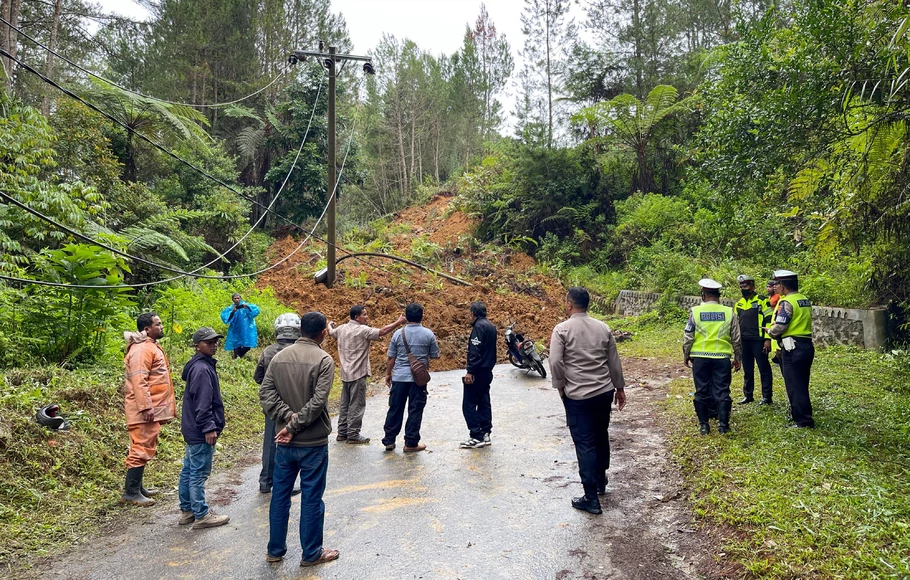 Sejumlah warga dan petugas kepolisian mengecek lokasi tanah longsor usai gempa bumi yang terjadi di kawasan Siatasbarita,Tapanuli Utara, Sumatra Utara, Sabtu, 1 Oktober 2022.