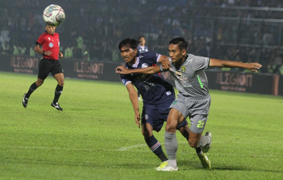 Pemain Arema FC Jayus Hariono (kiri) dan pemain Persebaya Surabaya Rizki Ridho berebut Bola dalam pertandingan lanjutan BRI Liga 1 di Stadion Kanjuruhan, Malang, Jawa Timur, Sabtu, 1 Oktober 2022.