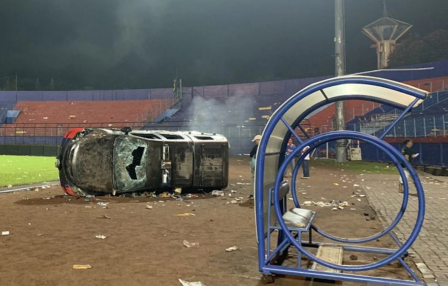 Sebuah mobil polisi rusak di lapangan Stadion Kanjuruhan, Kabupaten Malang, Jawa Timur akibat kericuhan yang terjadi seusai pertandingan antara Arema FC melawan Persebaya Surabaya, Sabtu, 1 Oktober 2022.