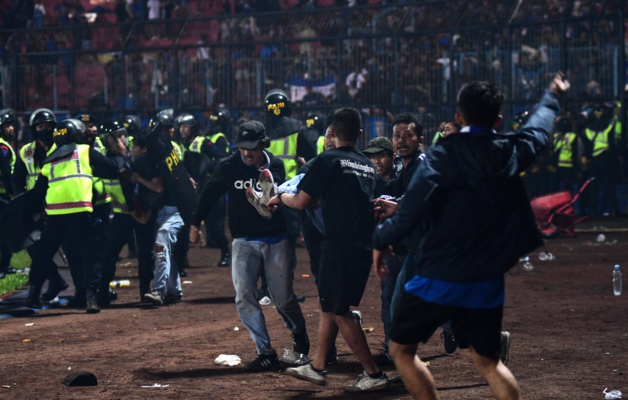 Seorang penonton korban kerusuhan dibawa untuk dievakuasi dalam pertandingan sepak bola antara Arema FC dan Persebaya Surabaya di stadion Kanjuruhan di Malang, Jawa Timur, Sabtu, 1 Oktober 2022.