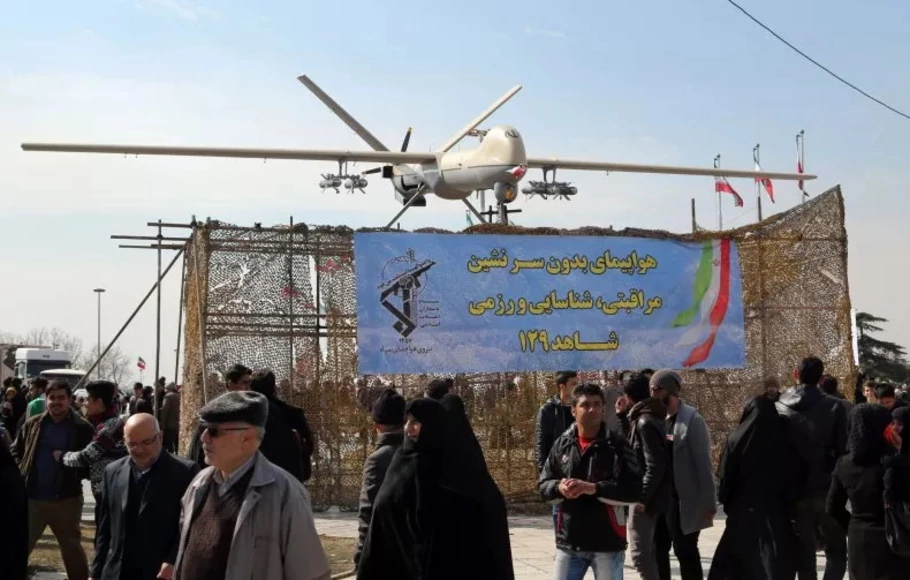 Orang-orang Iran berjalan melewati drone Shahed 129 Iran yang dipamerkan selama perayaan di Teheran untuk menandai peringatan 37 tahun revolusi Islam pada 11 Februari 2016.