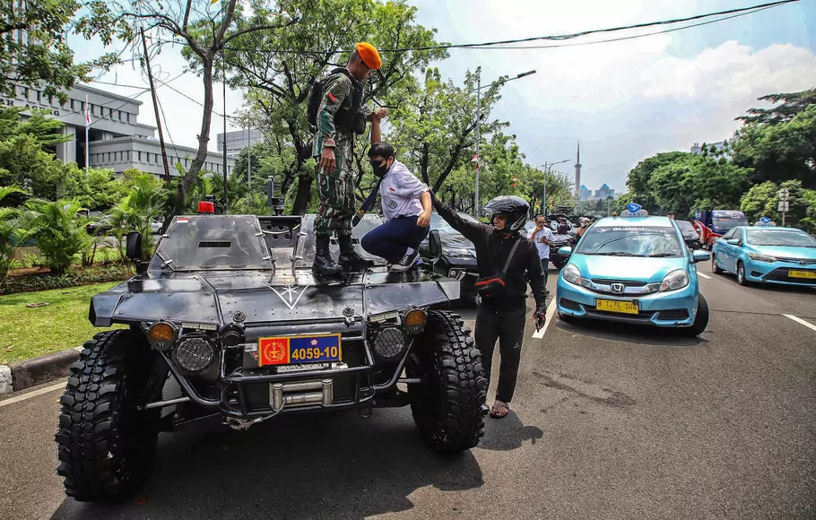 Warga berfoto bersama sejumlah kendaraan tempur milik TNI yang terparkir untuk dipamerkan saat HUT TNI ke -77 di Jalan Merdeka Utara, Jakarta, Selasa 4 Oktober 2022.