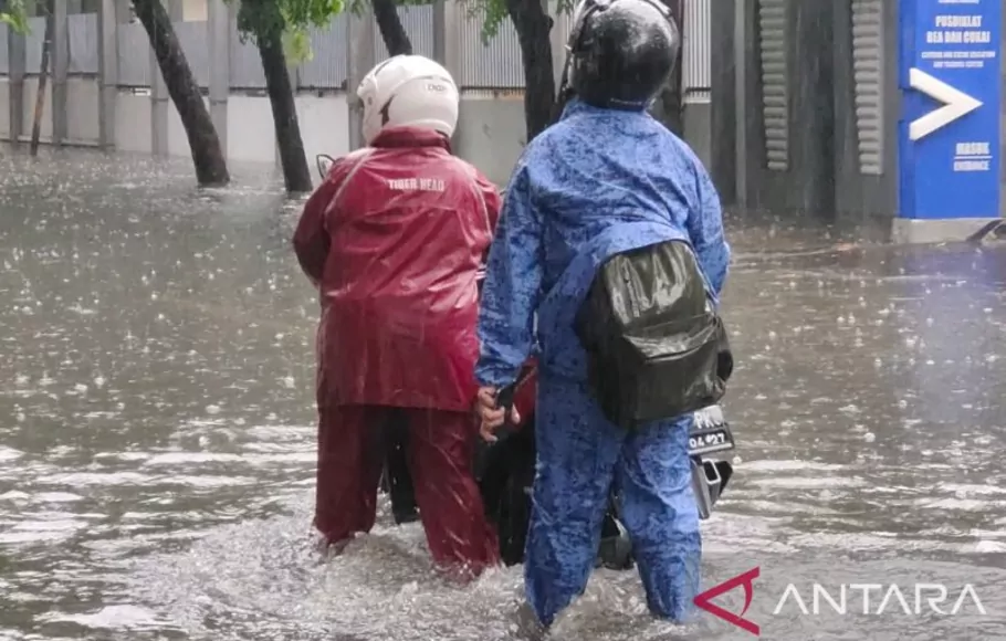 Pengendara motor melintasi jalan yang tergenang banjir di Pulogadung, Jakarta, Kamis 6 Oktober 2022.