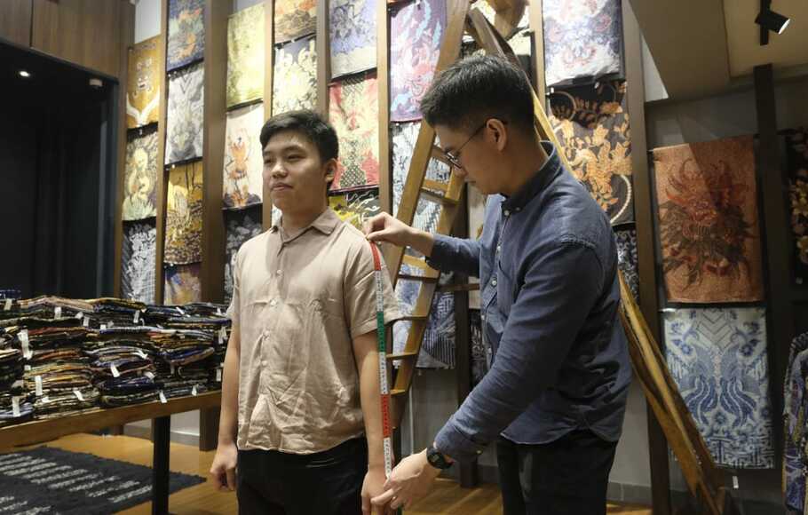 Pelanggan Batik Wolter mengukur baju di Jakarta.