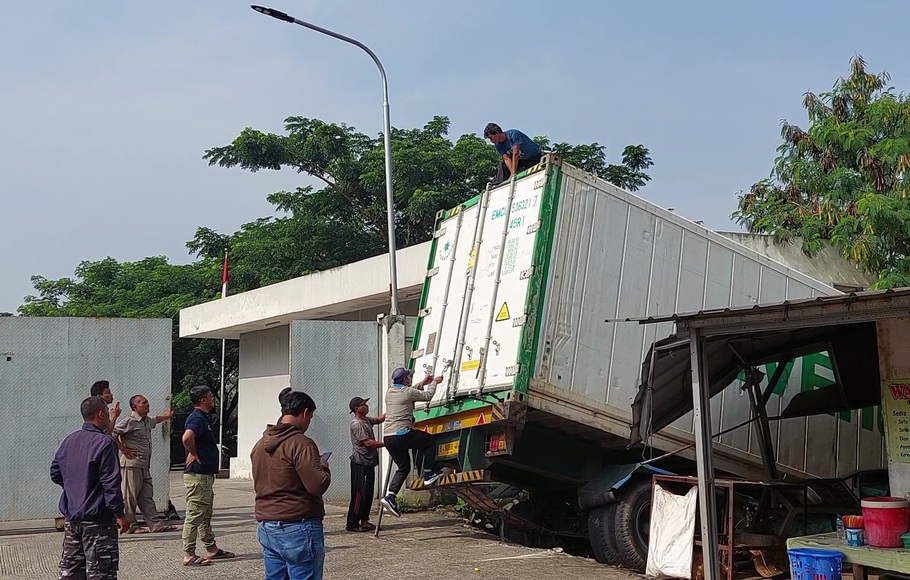 Truk kontainer bermuatan daging terjun ke tebing kali Cileungsi, Jalan Himalaya, Pangkalan 2, Bantargebang, Kota Bekasi, Jawa Barat, Sabtu, 15 Oktober 2022.