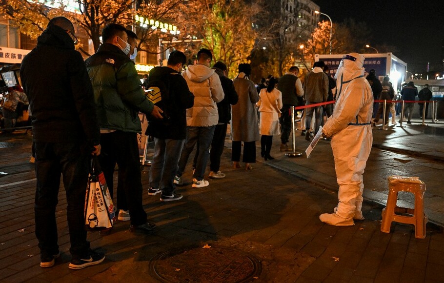Orang-orang mengantre untuk tes Covid-19 di stasiun pengambilan swab di Beijing, Tiongkok pada 15 November 2022.