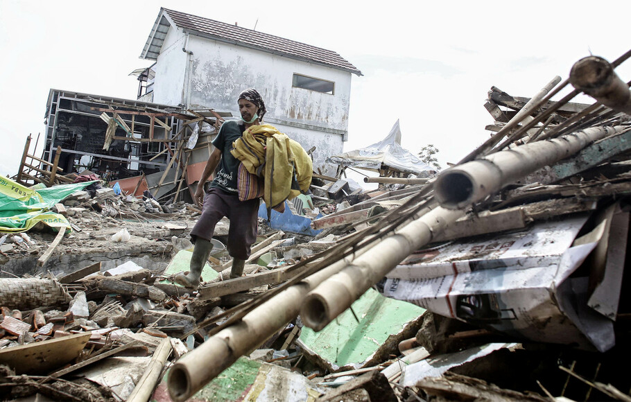 Seorang korban gempa mencari sisa barang miliknya di reruntuhan rumah di Desa Sukamulya, Kecamatan Cugenang Kabupaten Cianjur, Rabu 23 November 2022.