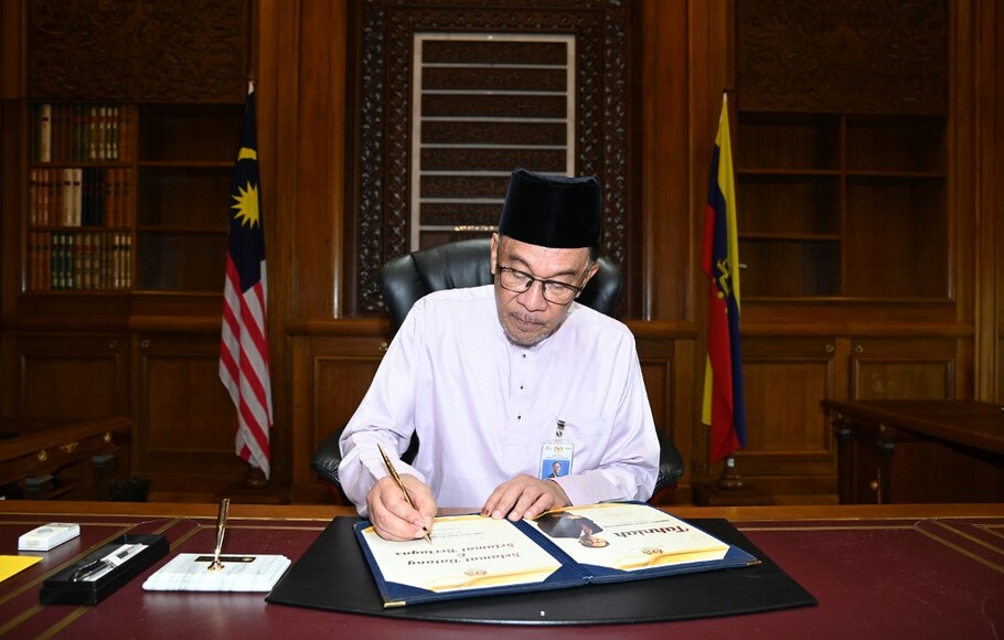 Perdana Menteri baru Malaysia Anwar Ibrahim menandatangani dokumen pada hari pertamanya di Kantor Perdana Menteri di Putrajaya.