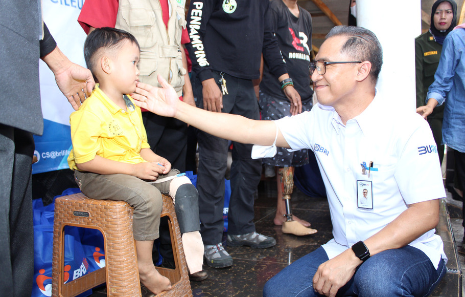 Direktur Utama BRI Life Iwan Pasila berbincang dengan salah seorang anak penyandang disabilitas penerima donasi kaki palsu di Cileungsi, Jawa Barat, Sabtu 3 Desember 2022.