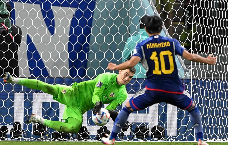 Kiper Kroasia Dominik Livakovic menahan tendangan penalti pemain Jepang Takumi Minamino.