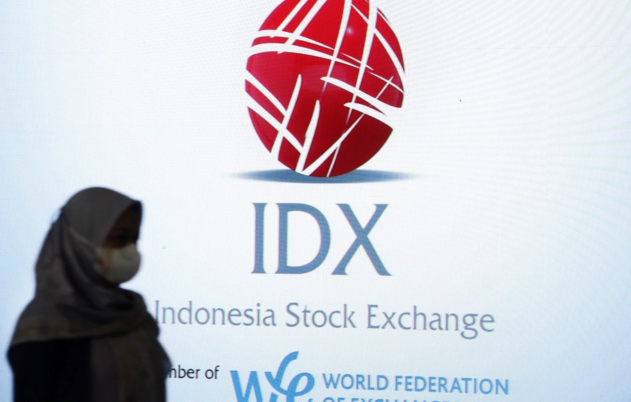 Pengunjung melintas di depan monitor saham Bursa Efek Indonesia (BEI), Jakarta.
