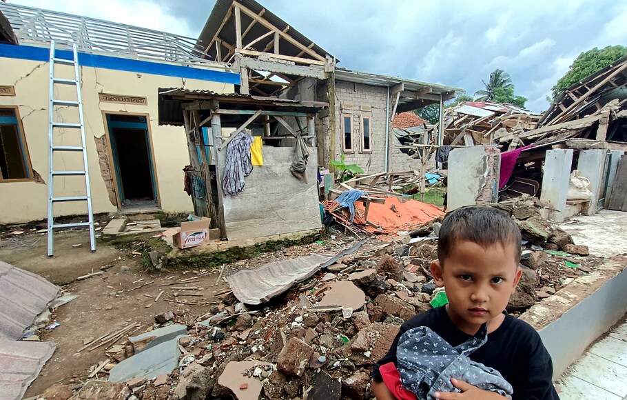 Seorang anak berdiri di rumahnya yang hancur akibat gempa di Kampung Gasol Cugenang, Kabupaten Cianjur, Jawa Barat, Sabtu, 10 desember 2022. Sejumlah korban gempa mengaku belum mengetahui kapan bantuan renovasi rumah direalisasikan.