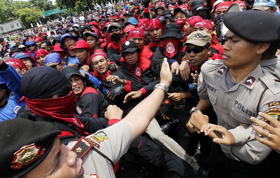 Ribuan buruh yang berunjuk rasa menolak kenaikan  harga bahan bakar minyak terlibat aksi dorong dengan petugas kepolisian saat berunjuk rasa di depan Istana Negara. FOTO : MAST IRHAM/EPA