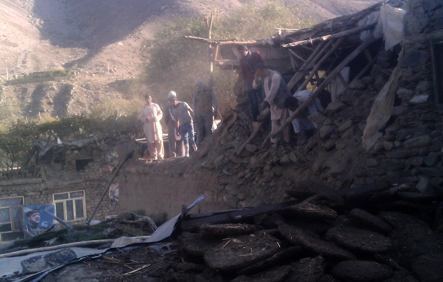 Sejumlah warga berdiri di dekat rumah yang hancur akibat gempa di distrik Bazarak, Provinsi Panjshir, Afghanistan, 26 Oktober 2015.