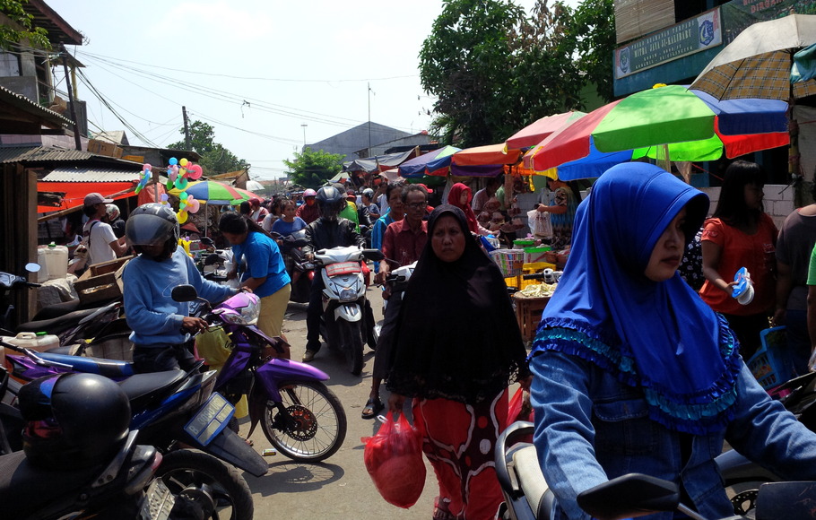 Pengendara motor melintasi pasar yang dipenuhi Pedagang Kaki Lima (PKL) di Jalan Kalibaru Timur II, Kelurahan Kalibaru, Kecamatan Cilincing, Jakarta Utara, yang semrawut dan dikeluhkan warga, 15 Oktober 2015