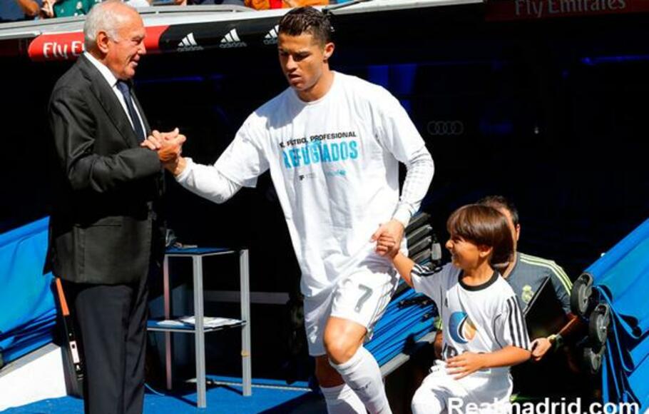 Cristiano Ronaldo menggandeng Zied, anak kecil pengungsi dari Suriah, ke lapangan Santiago Bernabeu sebelum Real Madrid melawan Granada.