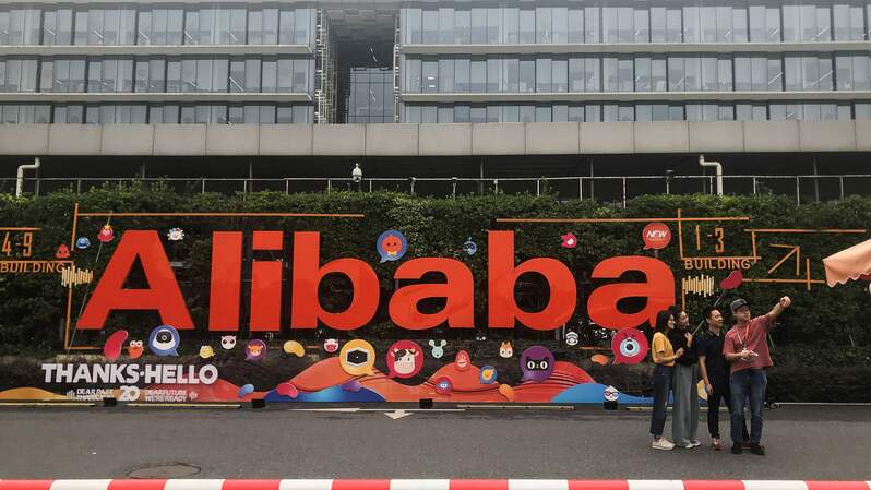Orang-orang sedang berfoto di markas raksasa perusahaan e-commerce Tiongkok, Alibaba di Hangzhou, Provinsi Zhejiang, Tiongkok timur. Foto diambil beberapa waktu sebelum pandemi pecah. (FOTO: KELLY WANG / DAN MARTIN / AFP)