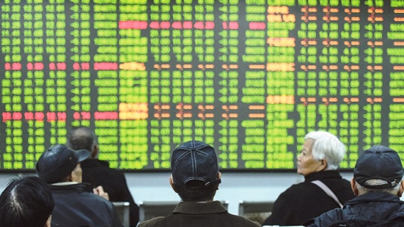 Investor memperhatikan layar yang menunjukkan pergerakan pasar saham di sebuah perusahaan sekuritas di Hangzhou, provinsi Zhejiang, Tiongkok. (STR / AFP)