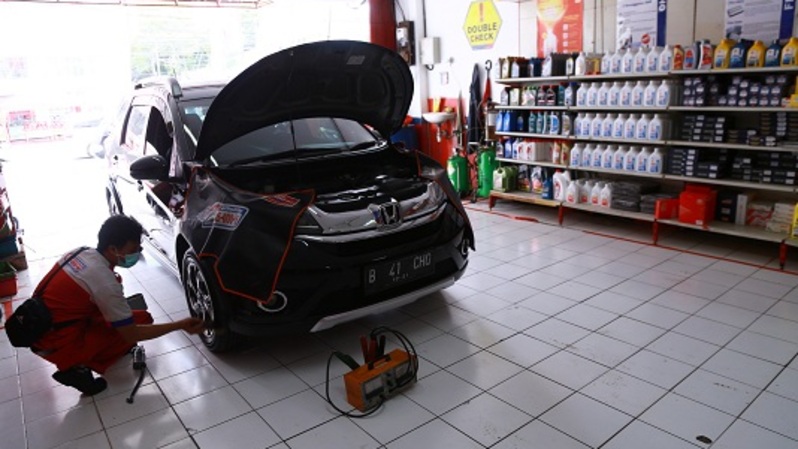 Petugas bengkel Shop&Drive mengecek kondisi mesin mobil konsumen di Jakarta, Kamis (26/3/2020). BeritaSatu Photo/Mohammad Defrizal