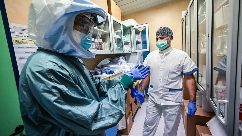 Seorang perawat memakai APD sebelum mulai bekerja di unit perawatan intensif (ICU) untuk pasien yang terinfeksi virus corona Covid-19 di RS Policlinico di Tor Vergata, Roma, Italia.  Foto: Andreas SOLARO / AFP 