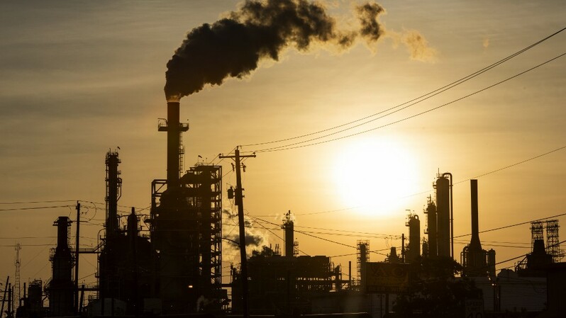 Matahari terbenam di balik asap yang mengepul dari kilang LyondellBasell-Houston Refining di kota Houston, Texas. Foto ilustrasi: Mark Felix/AFP