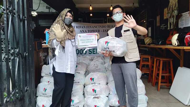 Manager of GA Rifan Financindo Berjangka (RFB)-AXA Tower Ibu Tovia menyerahkan bantuan kepada relawan turun tangan di bawah Forum Komunikasi seniman Jakarta Raya