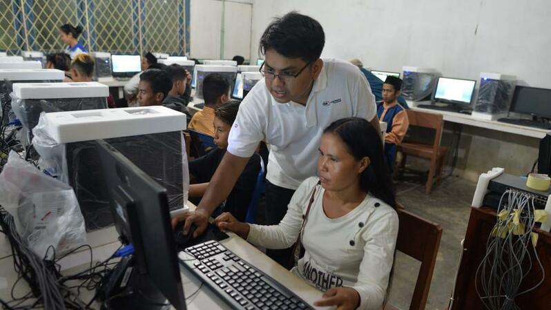 Guru di PKBM Mustika sedang mengajarkan keterampilan menggunakan komputer pada siswa