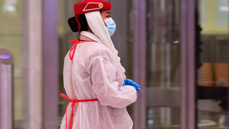 Staf maskapai mengenakan alat pelindung saat para wisatawan mendapatkan pemeriksaan medis setibanya di Teminal 3 di bandara Dubai, Uni Emirat Arab pada 8 Juli 2020. ( Foto: CACACE GIUSEPPE / AFP )