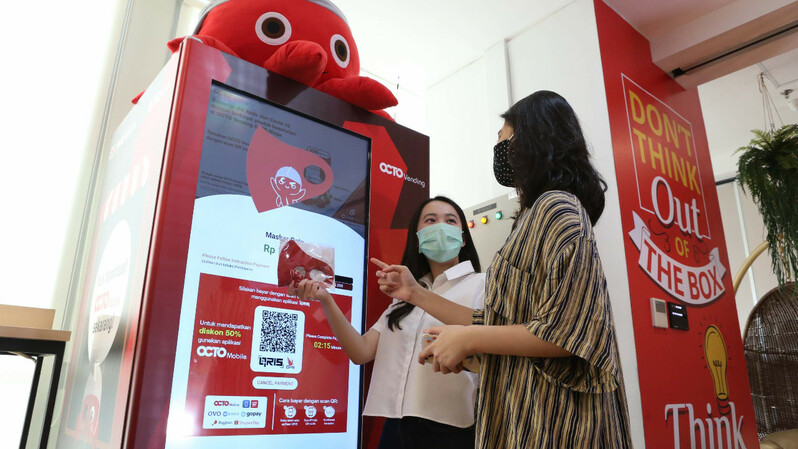 Nasabah berbincang usai melakukan pembelian masker menggunakan Scan QRIS OCTO Mobile di OCTO Vending CIMB Niaga di Jakarta, Rabu (22/7/2020). (ist)