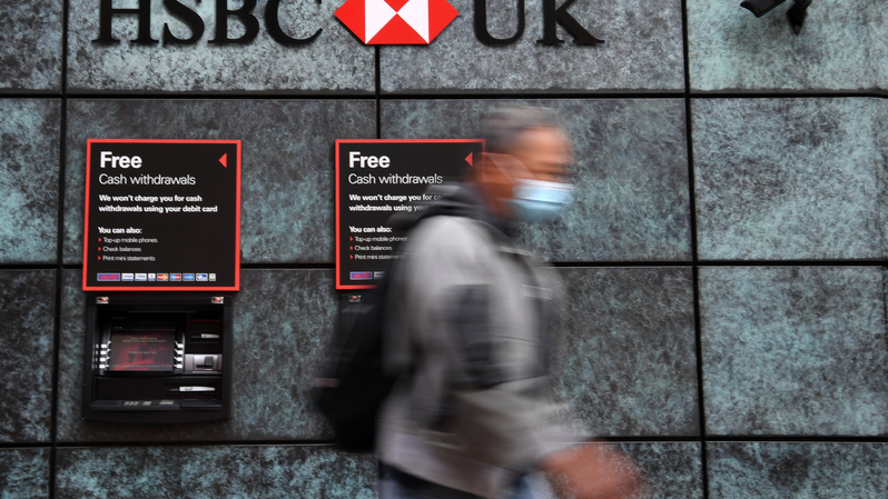 Seorang pejalan kaki mengenakan masker tengah melewati kantor cabang Bank HSBC di pusat kota London pada 3 Agustus 2020. ( Foto: DANIEL LEAL-OLIVAS / AFP )