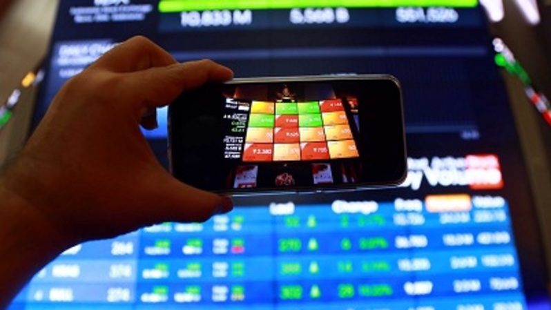 Investor menggunakan telepon pintar melihat pergerakan harga saham di Bursa Efek Indonesia (BEI) di Jakarta. Foto ilustrasi: BeritaSatu Photo/Mohammad Defrizal