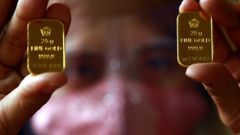 Pembeli menunjukan emas batangan. Foto ilustrasi:  BeritaSatu Photo/Mohammad Defrizal