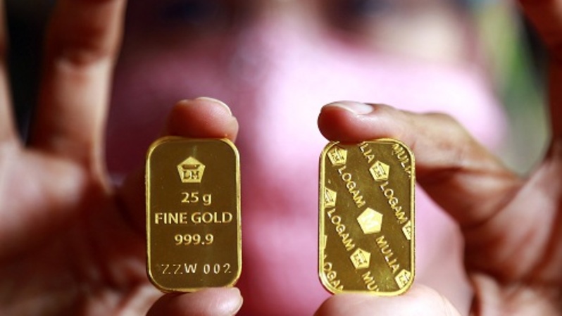 Pembeli menunjukan emas batangan. Foto ilustrasi:  BeritaSatu Photo/Mohammad Defrizal