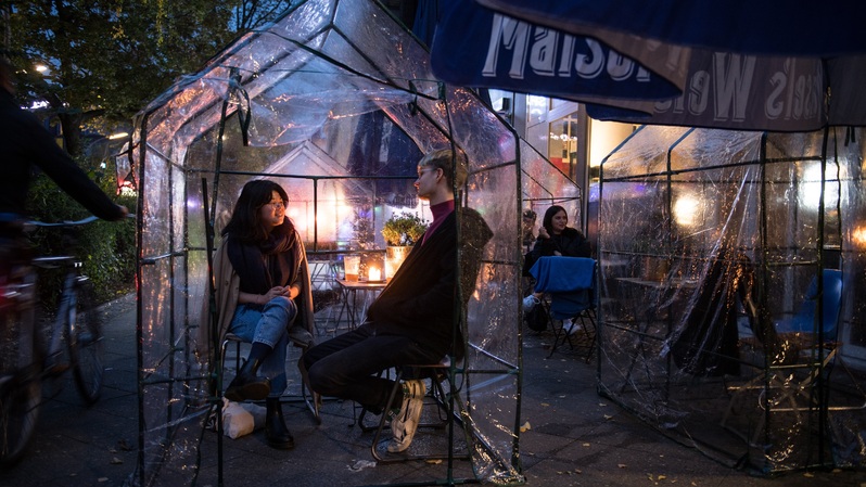 Para tamu duduk di rumah kaca kecil yang terbuat dari bahan plastik transparan sebagai upaya pencegahan penularan virus corona Covid-19, saat berada di kedai kopi dan bar di Berlin, Jerman pada 20 Oktober 2020. Foto ilustrasi: STEFANIE LOOS / AFP 