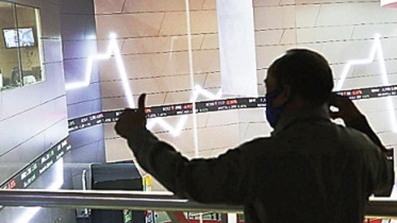 Petugas berjaga dengan latar belakang monitor pergerakan harga saham di Bursa Efek Indonesia di Jakarta. Foto ilustrasi:  Beritasatu Photo/Uthan A Rachim