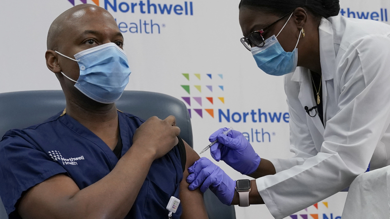 Karyawan Northwell Health sekaligus Ketua Pengobatan Darurat Yves Duroseau menerima suntikan vaksin Covid-19 di Rumah Sakit Lenox Hill, di Pusat Kesehatan Long Island Jewish, pada 14 Desember 2020. ( Foto: Timothy A. Clary / AFP )