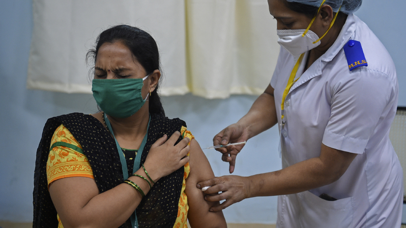 Seorang tenaga medis sedang menyuntikkan rekannya dengan vaksin Covid-19 di Rumah Sakit Rajawadi di Mumbai, India. Foto ilustrasi: Punit Paranjpe / AFP 