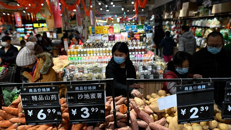 Orang-orang tengah memilih sayuran di sebuah supermarket di Beijing, Tiongkok, pada 10 Februari 2021. (FOTO: Wang Zhao / AFP)