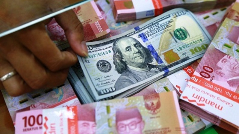 Mata uang dolar AS di antara mata uang rupiah di sebuah penukaran uang di Jakarta.  Foto:  BeritaSatu Photo/Mohammad Defrizal
