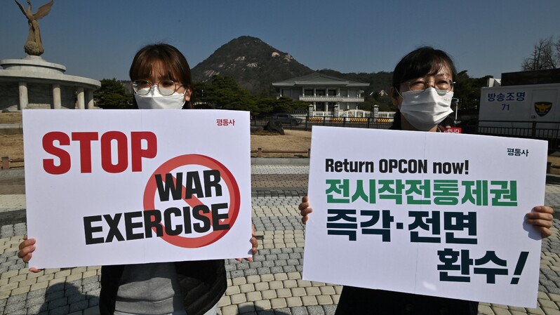 Para aktivis anti-perang memegang poster bertuliskan: Hentikan latihan perang! selama menggelar protes menentang latihan militer gabungan antara Korea Selatan (Korsel) dan Amerika Serikat (AS), di dekat Gedung Biru kepresidenan di Seoul, pada 8 Maret 2021. ( Foto: Jung Yeon-je / AFP ) 