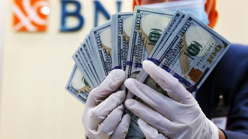 Karyawan BNI memperlihatkan mata uang dolar di Jakarta. Foto ilustrasi: Beritasatu Photo/Uthan AR 